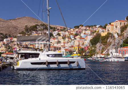 Bright multi-colored facades of houses on the shore of the bay in the village Symi Bright multi-colored facades of houses on the shore of the bay in the village Symi 116543065