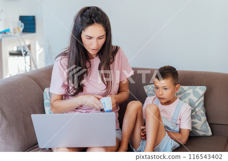 Stressed mother talking with pediatrician doctor during online video chat on pc, worried about her son's health, checking child's temperature by holding hand on kid forehead. Telemedicine, telehealth. 116543402
