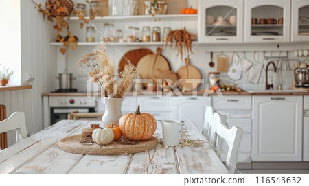 a cozy kitchen decorated for autumn, featuring pumpkins, dried flowers, and warm, rustic elements  116543632