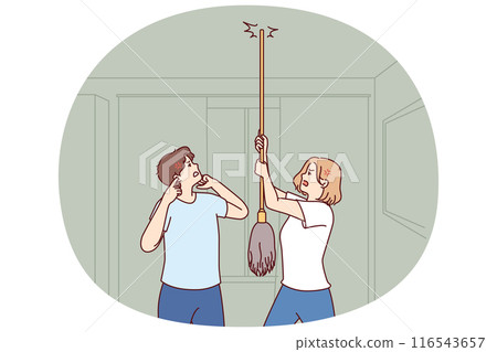 Young couple bangs on ceiling with mop urging neighbors to stop party or turn off loud music 116543657