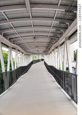 Pedestrian pathway or corridor or hallway between train station and building. Pedestrian pathway or corridor or hallway between train station and building. 116544327