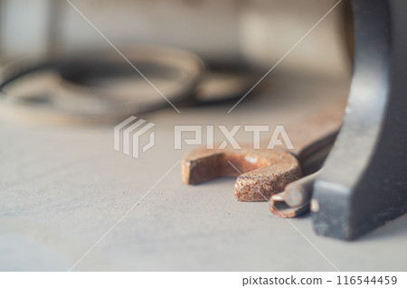 Locksmith tools such as a wrench and an adjustable wrench with selective focus lie on a beige surface and gather dust idle. Locksmith tools such as a wrench and an adjustable wrench with selective focus lie on a beige surface and gather dust idle. 116544459