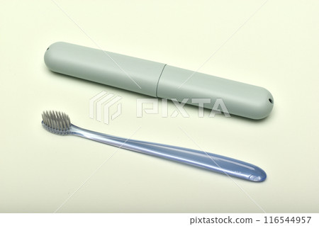 A toothbrush case and a toothbrush on a green background. 116544957