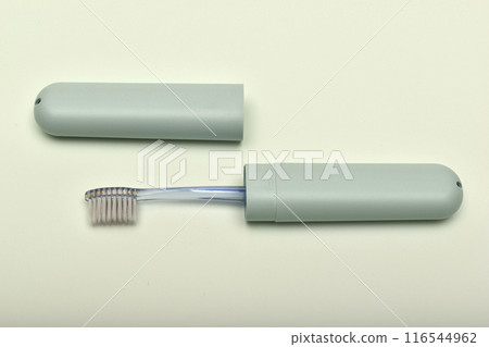 A toothbrush case and a toothbrush on a green background. A toothbrush case and a toothbrush on a green background. 116544962