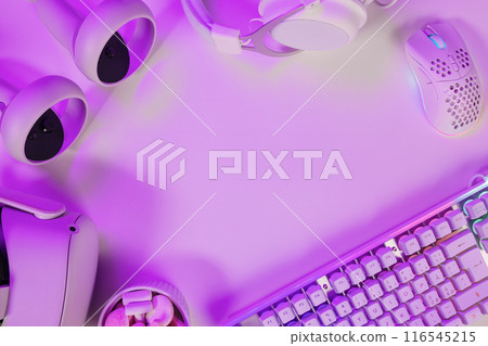 Keyboard with gadgets on illuminated purple desk Keyboard with gadgets on illuminated purple desk 116545215
