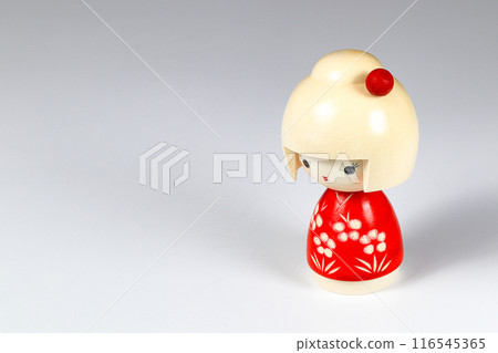 Japanese wooden dolls "kokeshi" in red Kimono suit, toy for a decoration, souvenir from Japan Isolated on white background. Japanese wooden dolls "kokeshi" in red Kimono suit, toy for a decoration, souvenir from Japan Isolated on white background. 116545365