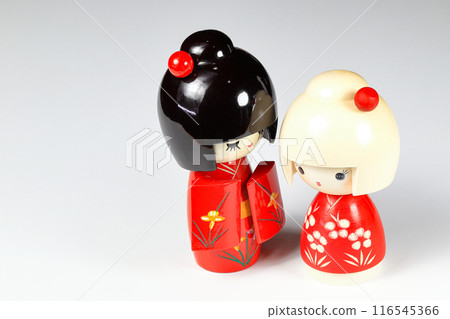 Japanese wooden dolls "kokeshi" in red Kimono suit, toy for a decoration, souvenir from Japan Isolated on white background. 116545366