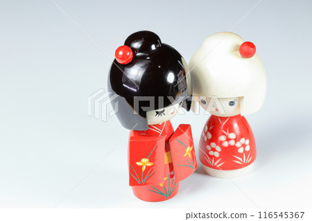 Japanese wooden dolls "kokeshi" in red Kimono suit, toy for a decoration, souvenir from Japan Isolated on white background. Japanese wooden dolls "kokeshi" in red Kimono suit, toy for a decoration, souvenir from Japan Isolated on white background. 116545367