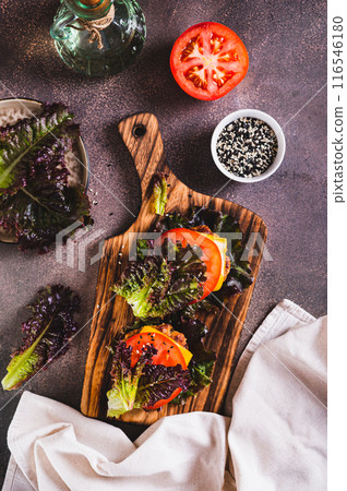 Juicy keto burgers on fresh lettuce leaves of cutlet, tomato and cheese top and vertical view Juicy keto burgers on fresh lettuce leaves of cutlet, tomato and cheese top and vertical view 116546180