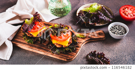 Keto burgers on lettuce leaves from cutlet, tomatoes and cheese on a board web banner Keto burgers on lettuce leaves from cutlet, tomatoes and cheese on a board web banner 116546182