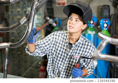Young woman working with welding machine 116548190