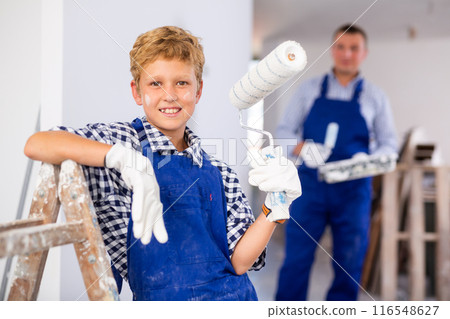 Portrait of positive young boy with paint roller 116548627