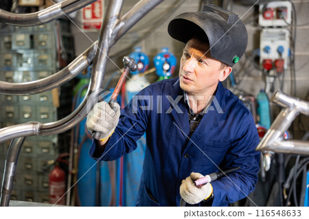 Man using welder for construction work at workshop Man using welder for construction work at workshop 116548633