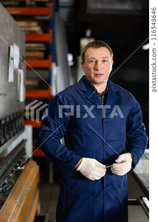 Experienced middle-aged worker posing in professional metalworking workshop Experienced middle-aged worker posing in professional metalworking workshop 116548646