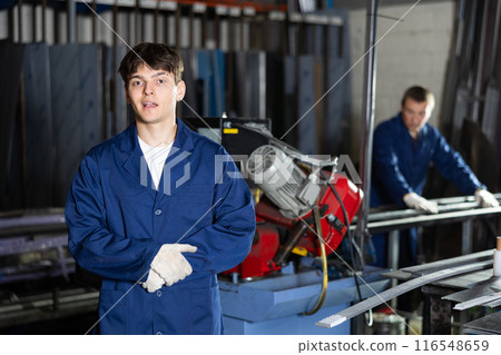 Portrait of male worker in a robe in workshop of metallurgical plant 116548659