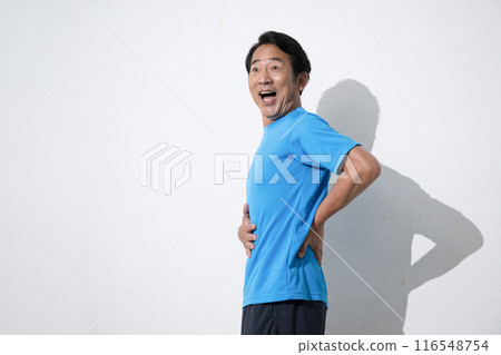 A middle-aged man touching his stomach with concern. An image of a middle-aged man's successful diet. 116548754