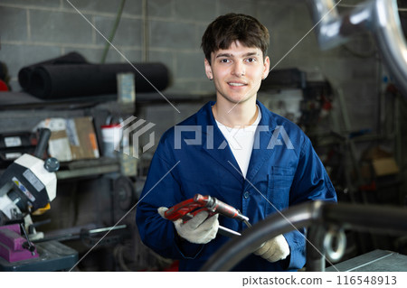 Young guy posing with vice in workshop 116548913