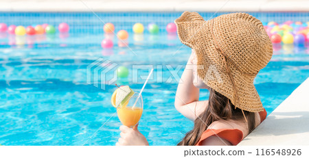 年輕的亞洲女性在度假村度假時在泳池裡喝熱帶飲料 116548926