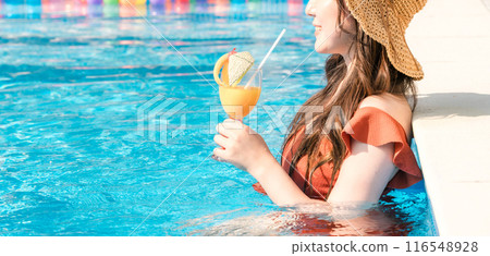 Young Asian woman drinking a tropical drink in the pool on resort vacation Young Asian woman drinking a tropical drink in the pool on resort vacation 116548928