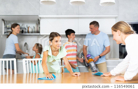 Teenage girls wash dining tables and help to do household chores, family day. 116549061