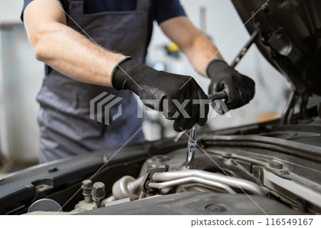 Mechanic working on car engine in service garage workshop 116549167