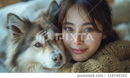 A woman rubbing her cheek against a dog 116549263