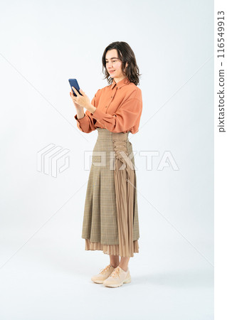 Full body photo of a white woman using a smartphone Full body photo of a white woman using a smartphone 116549913