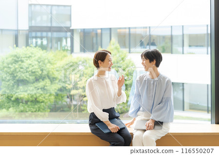 Two businesswomen talking with smiles 116550207