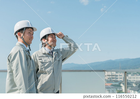 Workers wearing work clothes standing in the blue sky (construction, architecture, design, real estate, civil engineering, construction, site supervision, transportation) 116550212