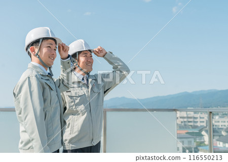 Workers wearing work clothes standing in the blue sky (construction, architecture, design, real estate, civil engineering, construction, site supervision, transportation) 116550213