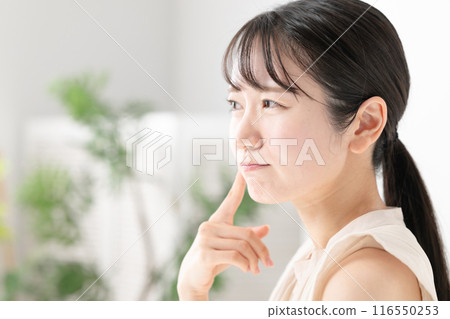 一個女人照鏡子檢查自己的皮膚狀況 一個女人照鏡子檢查自己的皮膚狀況 116550253