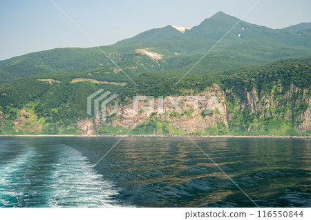 The cliff coastline and the majestic figure of Mt. Iou seen from the deck of a cruise ship on the Shiretoko Peninsula The cliff coastline and the majestic figure of Mt. Iou seen from the deck of a cruise ship on the Shiretoko Peninsula 116550844
