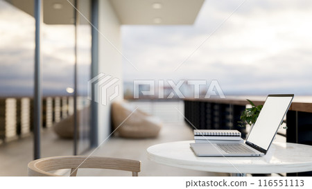A laptop computer on a table on an apartment balcony with an ocean view. outdoors workspace 116551113