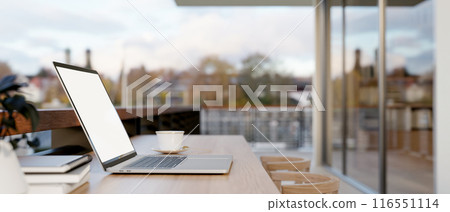 A laptop computer on a table on an apartment balcony with city view. outdoors workspace 116551114