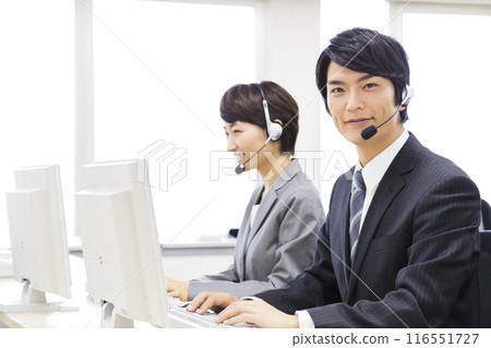Male and female business people working in a call center 116551727