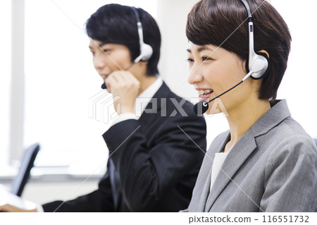 Male and female business people working in a call center 116551732