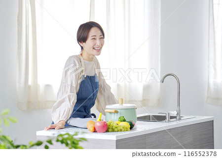 Portrait of a woman standing in the kitchen 116552378