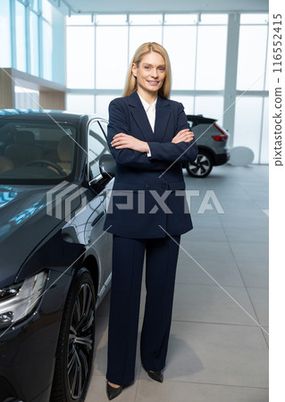 Female sale assistant in elegant suit in a car showroom 116552415