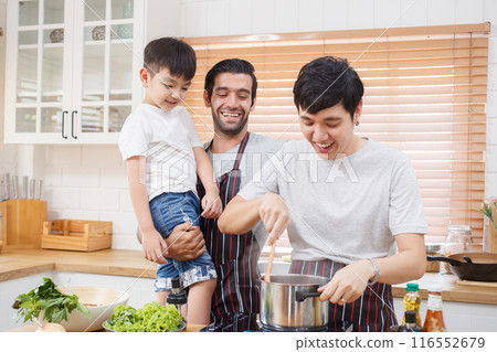 Happy cheerful LGBTQ couple cooking a food together in kitchen, a LGBT couple with adopted child cooking a food. Diversity lifestyles concept. 116552679