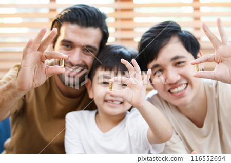Happy cheerful Asian men and little boy showing the fish oil capsule supplement to camera. 116552694
