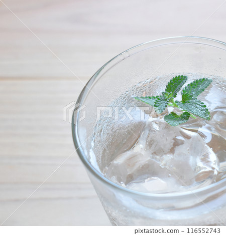 冷冰和水在玻璃杯中的特寫鏡頭,上面有水滴。 冷冰和水在玻璃杯中的特寫鏡頭,上面有水滴。 116552743
