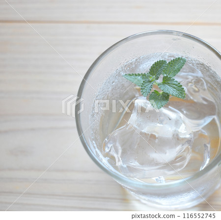 冷冰和水在玻璃杯中的特寫鏡頭,上面有水滴。 冷冰和水在玻璃杯中的特寫鏡頭,上面有水滴。 116552745