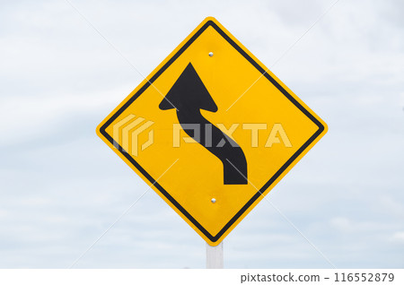 Left curve warning sign is on sky background. Left curve warning sign is on sky background. 116552879