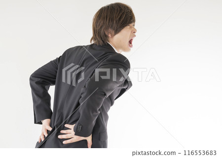 A young man suffering from low back pain A young man suffering from low back pain 116553683