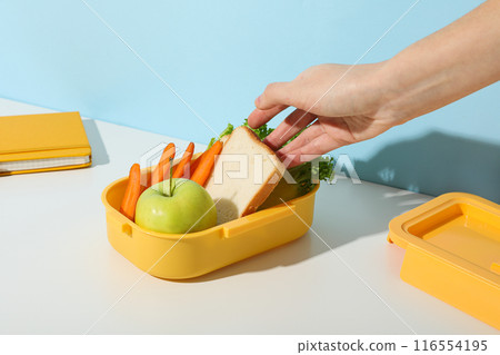 Yellow lunch box with bread, apple and carrot Yellow lunch box with bread, apple and carrot 116554195