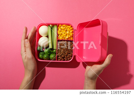 Pink lunch box with healthy food on a pink background Pink lunch box with healthy food on a pink background 116554197