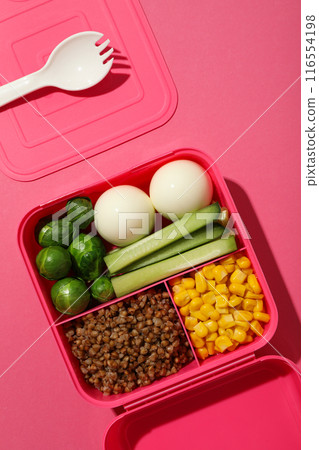 Pink lunch box with healthy food on a pink background Pink lunch box with healthy food on a pink background 116554198