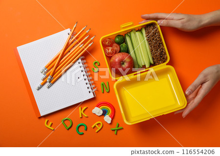 Yellow lunch box with delicious food and school supplies 116554206