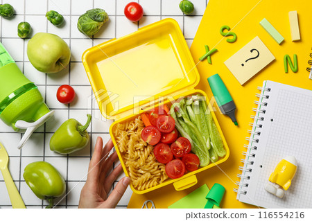 Yellow lunch box with food on a light background Yellow lunch box with food on a light background 116554216