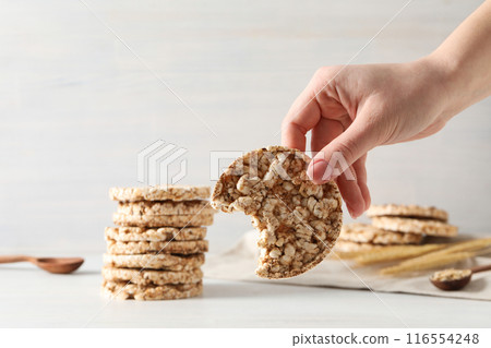 Crisps bread in hand, on a white background. 116554248
